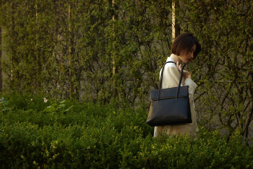 Une femme porte un sac Il Bisonte dans le style Anna