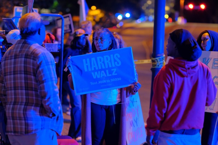 Les partisans de Kamala Harris tiennent des pancartes indiquant « Harris Walz » et « My Body My Choice » lors d'un rassemblement en soirée