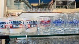 La photo montre plusieurs verres à shot portant le nom de Harris ou de Trump.