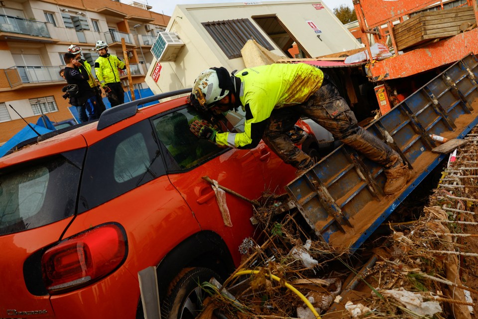 Un pompier regarde à l'intérieur d'une voiture après de fortes pluies à Alfafar