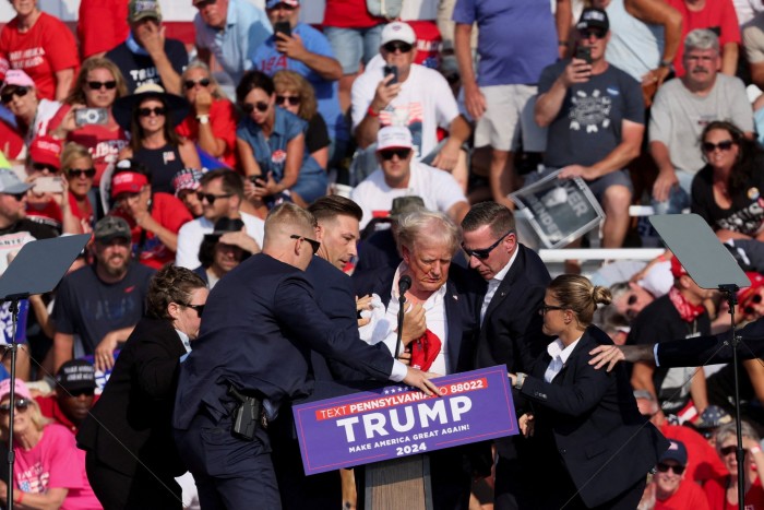 Le candidat républicain Donald Trump entouré d'agents des services secrets après des coups de feu lors d'un rassemblement électoral à Butler, en Pennsylvanie, en juillet