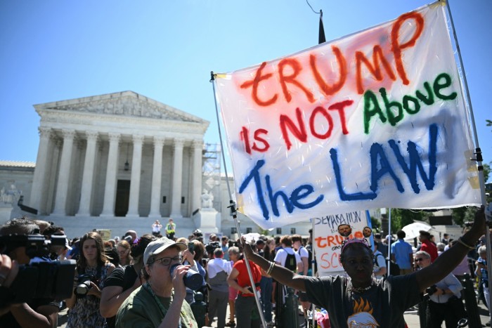 Des gens brandissent des pancartes anti-Trump devant la Cour suprême des États-Unis, le 1er juillet 2024, à Washington, DC.