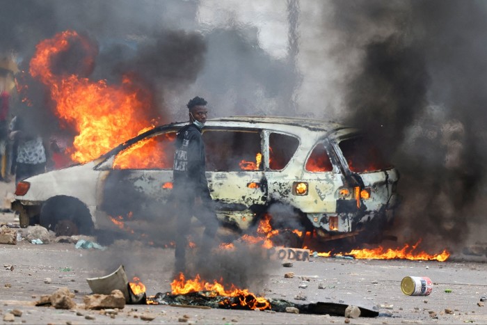 Un manifestant regarde près d'une barricade en feu lors d'un « arrêt national » contre le résultat des élections, à Maputo, au Mozambique