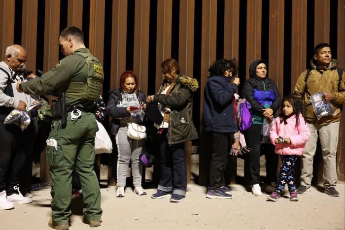 Les demandeurs d'asile aux États-Unis font la queue pendant qu'ils sont traités par les agents de la patrouille frontalière après avoir traversé l'Arizona. 