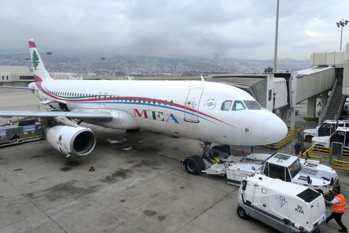 De la fumée s'élève en arrière-plan à Beyrouth alors qu'un Airbus A320 de Middle East Airlines attend les passagers 