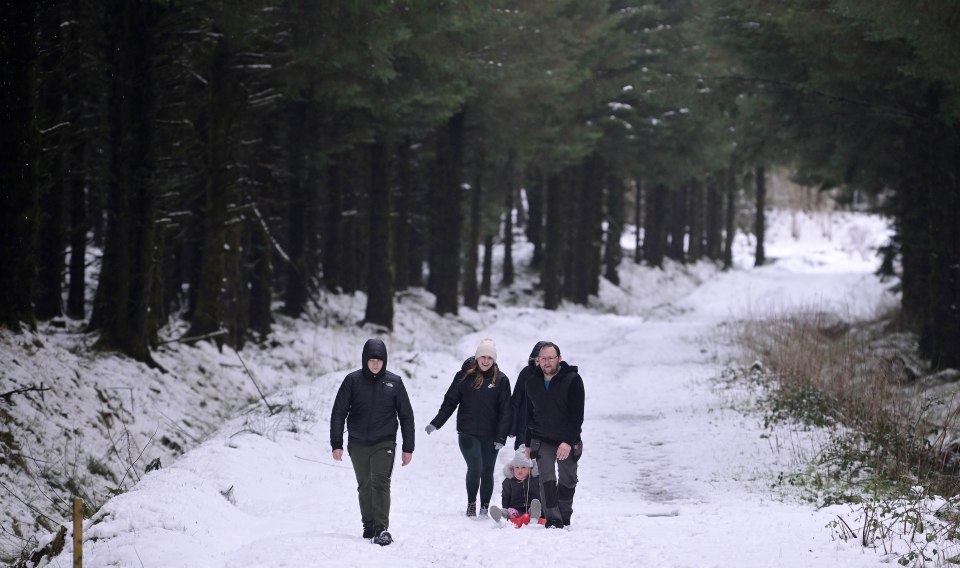 Une famille se promenant à Portstewart, en Irlande du Nord, en mars