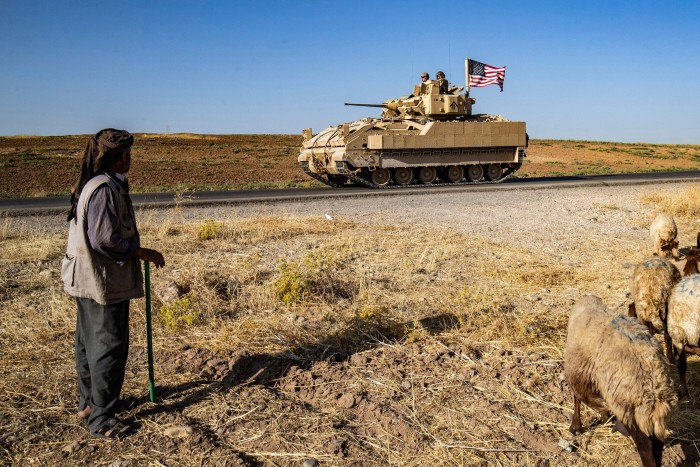 Des soldats américains à bord d'un véhicule de combat Bradley patrouillent dans la campagne de la ville d'al-Malikiya, dans la province syrienne de Hasakeh, au nord-est de la Syrie. 