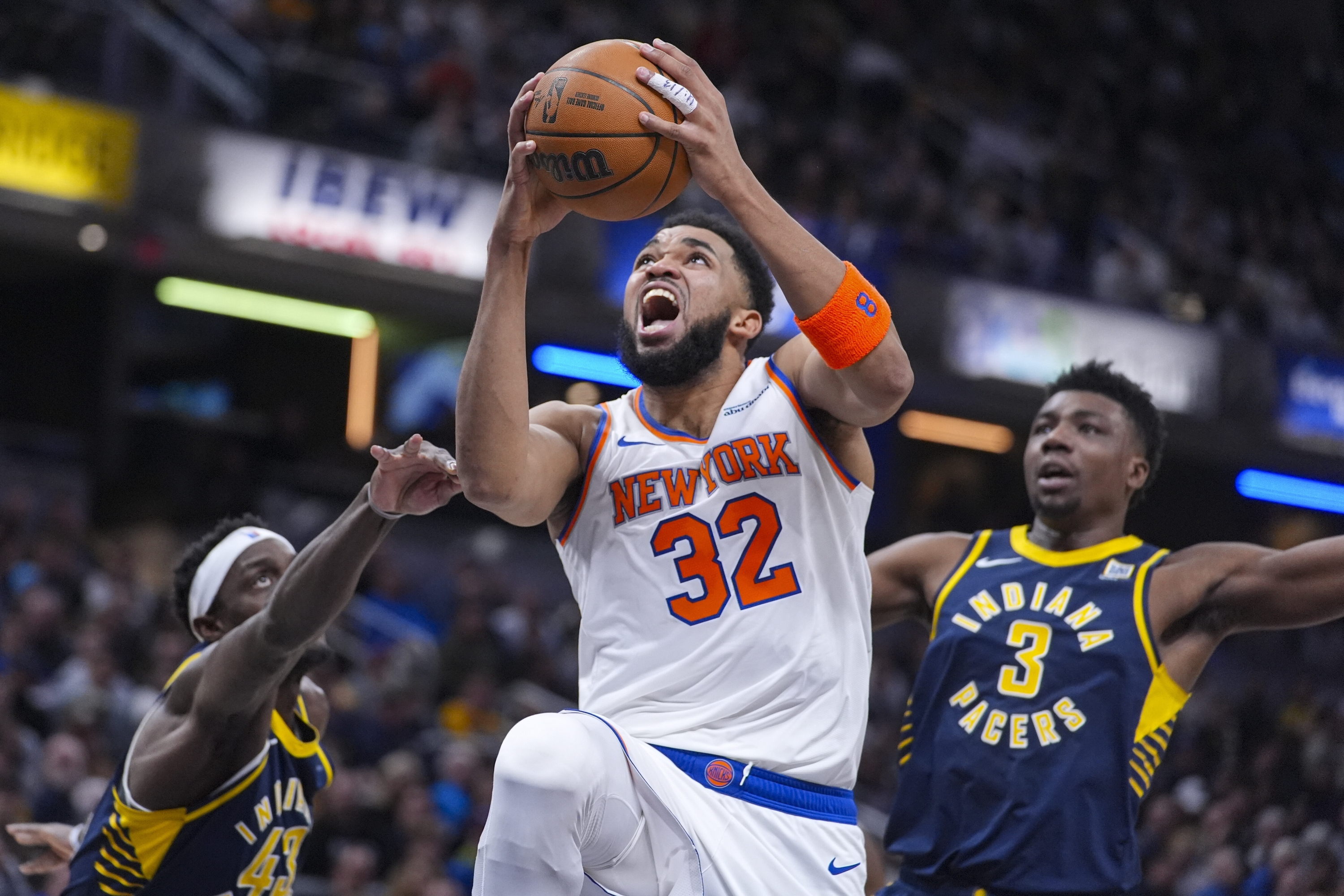 Le centre de New York Knicks Karl-Anthony Towns (32) tire sur Bethaeen Indiana Pacers Forward Pascal Siakam (43) et le centre Thomas Bryant (3) lors de la première moitié d'un match de basket-ball de la NBA à Indianapolis, mardi 11 février 2025. (AP Photo / Michael Conroy)