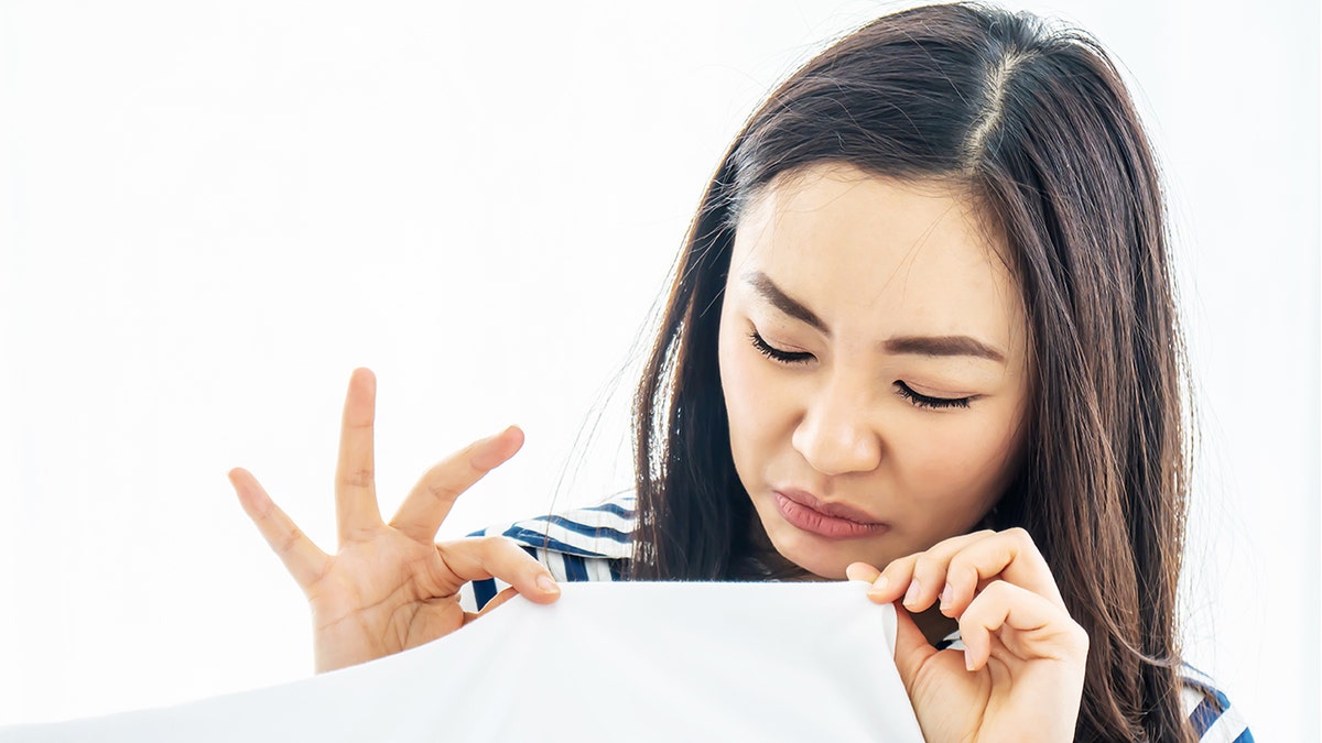 woman inspecting pillow