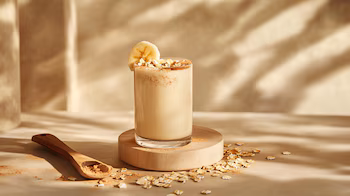 Smoothie épais à la banane avec flocons d'avoine et une touche de cannelle, idéal pour une boisson saine et savoureuse.