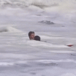Un jeune maître-nageur sauve un enfant des vagues dangereuses à la plage de Santa Cruz