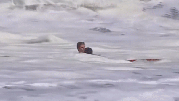 Un jeune maître-nageur sauve un enfant des vagues dangereuses à la plage de Santa Cruz