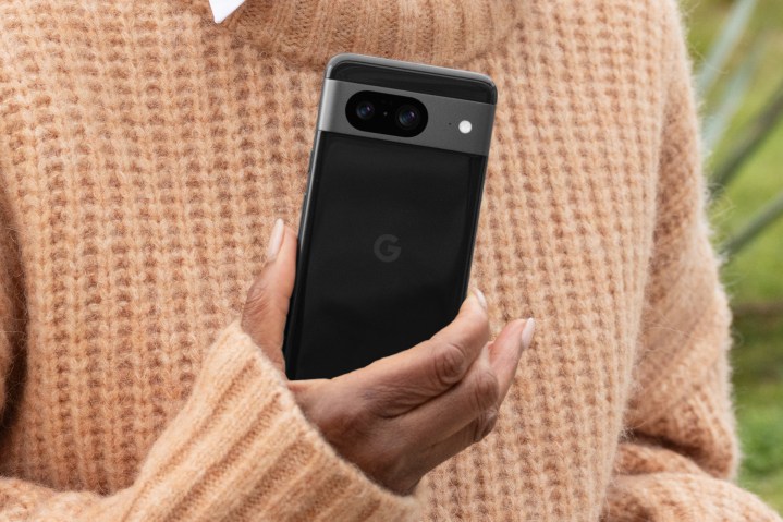 Siyah Google Pixel 8, kazak giyen bir kişinin elinde.