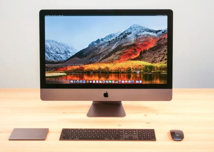 Ekranında macOS High Sierra masaüstünün bulunduğu, masa üzerinde bir Apple iMac Pro.