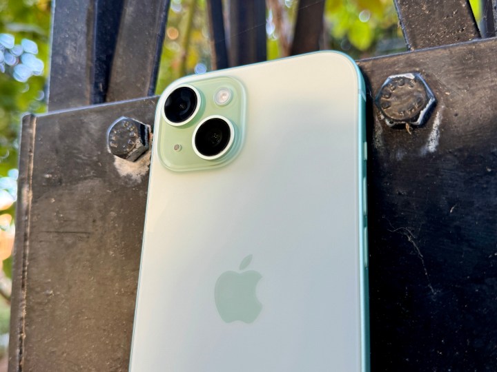 Kamerayı ve mat cam arka kısmı gösteren yeşil bir iPhone 15.