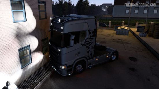 Işıklarını yakındaki bir duvara aydınlatan bir kamyon