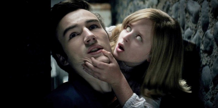 Ouija: Kötülüğün Kökeni'nde bir kız bir adamın çenesini tutuyor.