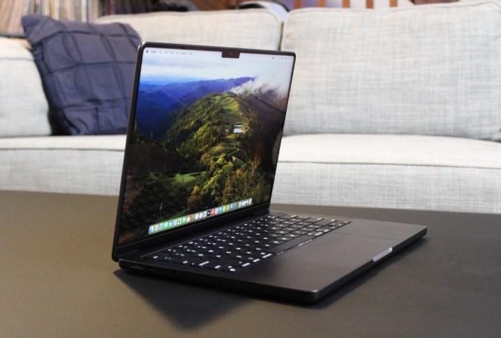 MacBook Pro kanepenin önündeki masanın üzerinde açık.