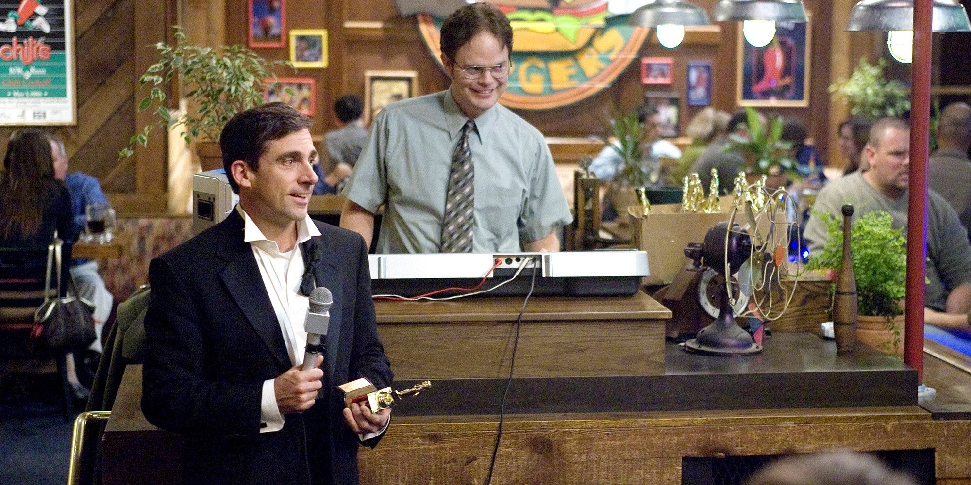 Dwight The Office'teki Dundies'de sunuculuk yaparken Michael elinde bir Dundie tutuyor.