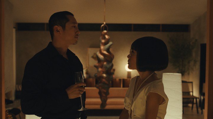 Netflix'teki Beef filminden bir sahnede karanlıkta bir adam ve kadın birbirlerine öfkeyle bakıyor.
