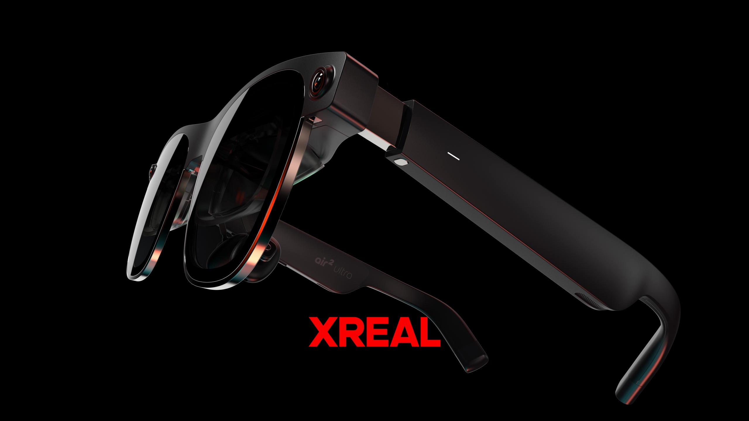 Xreal Air 2 Ultra, altında kırmızı 'Xreal' yazan siyah bir arka planın önünde süzülüyor