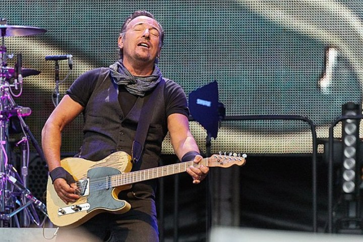 Bruce Springsteen konserde gitarını tutuyor.