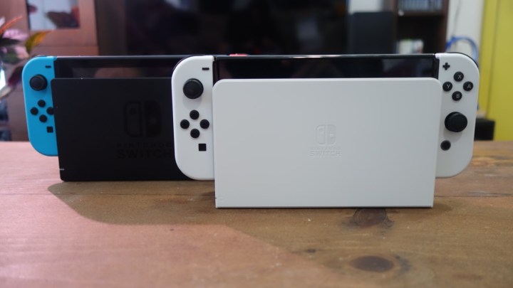 Normal bir Switch yuvasının yanındaki yuvasında bir Nintendo Switch OLED modeli.
