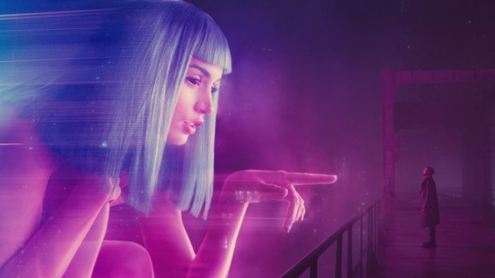 Memur K, Blade Runner 2049'daki neon renkli holograma bakıyor.