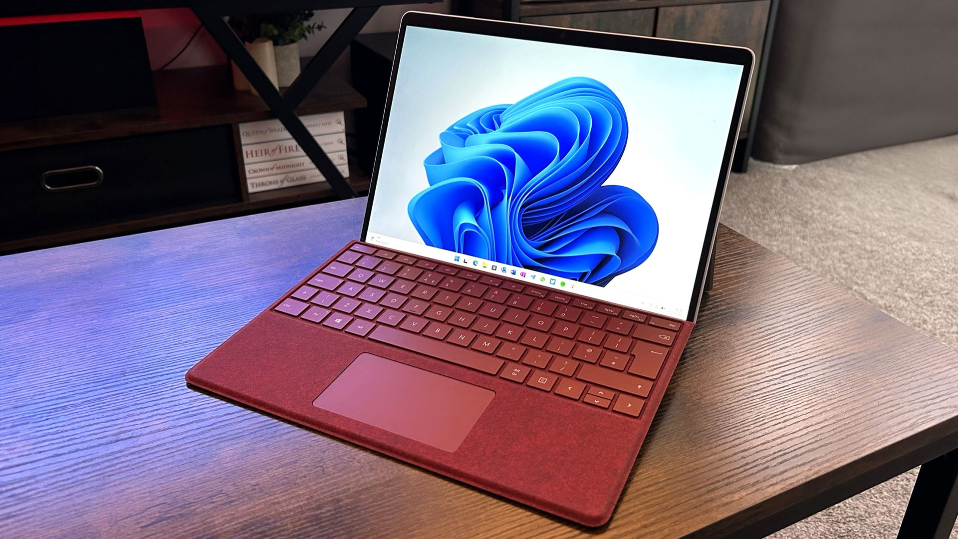 Microsoft Surface Pro 9 ahşap bir masa üzerinde kırmızı renkte