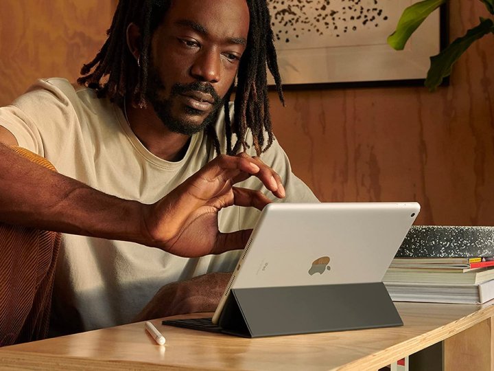 Bir adam masasında Apple iPad 2021 üzerinde çalışıyor.