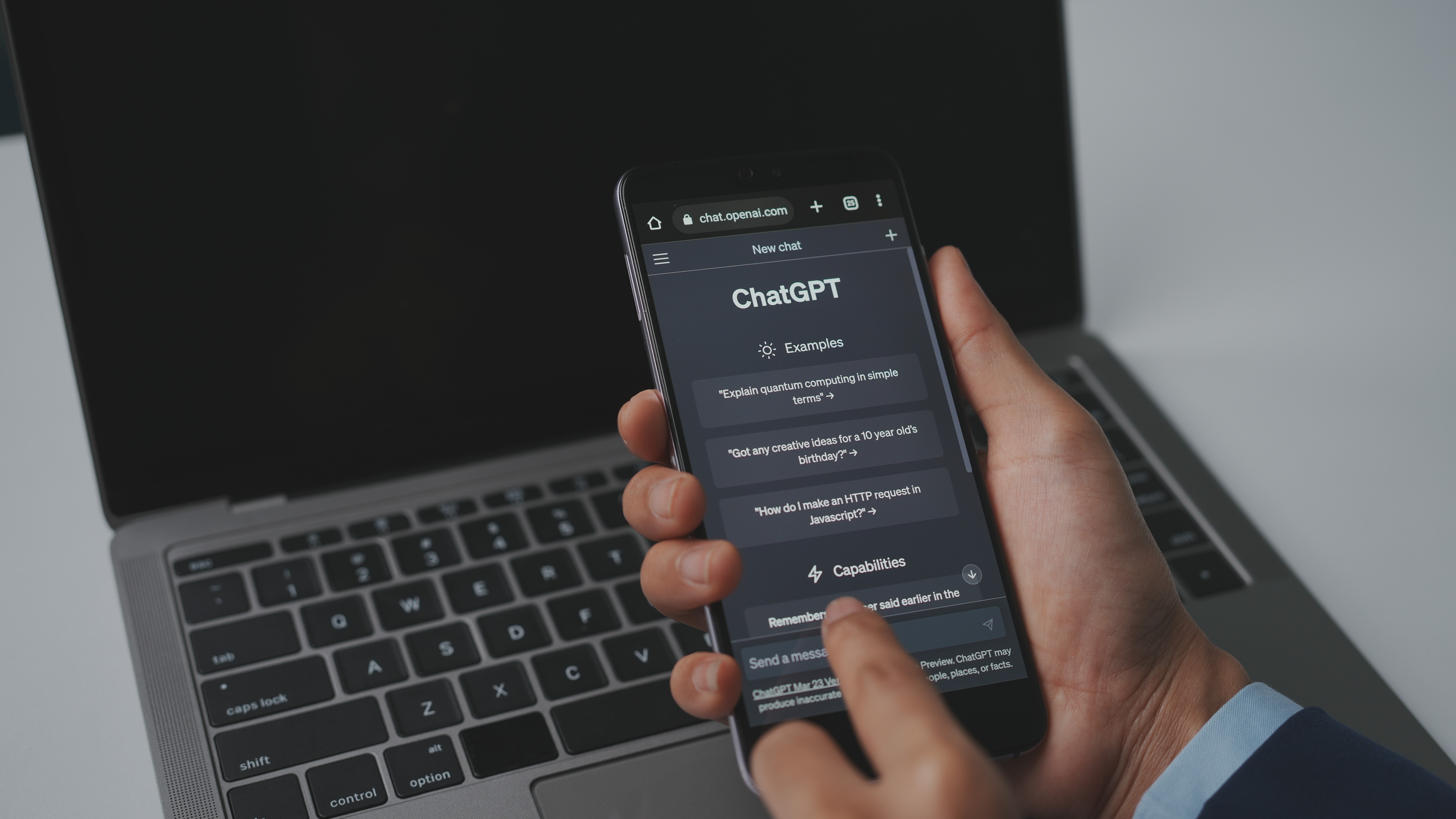ChatGPT'yi görüntüleyen bir telefonu tutan adam, OpenAI tarafından geliştirilen yapay zeka chatbotunun prototipidir.