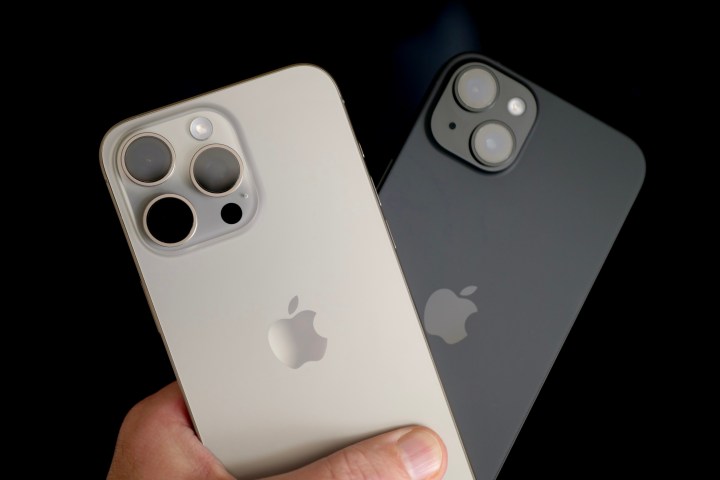Apple iPhone 15 Plus ve Apple iPhone 15 Pro Max'i tutan bir kişi.