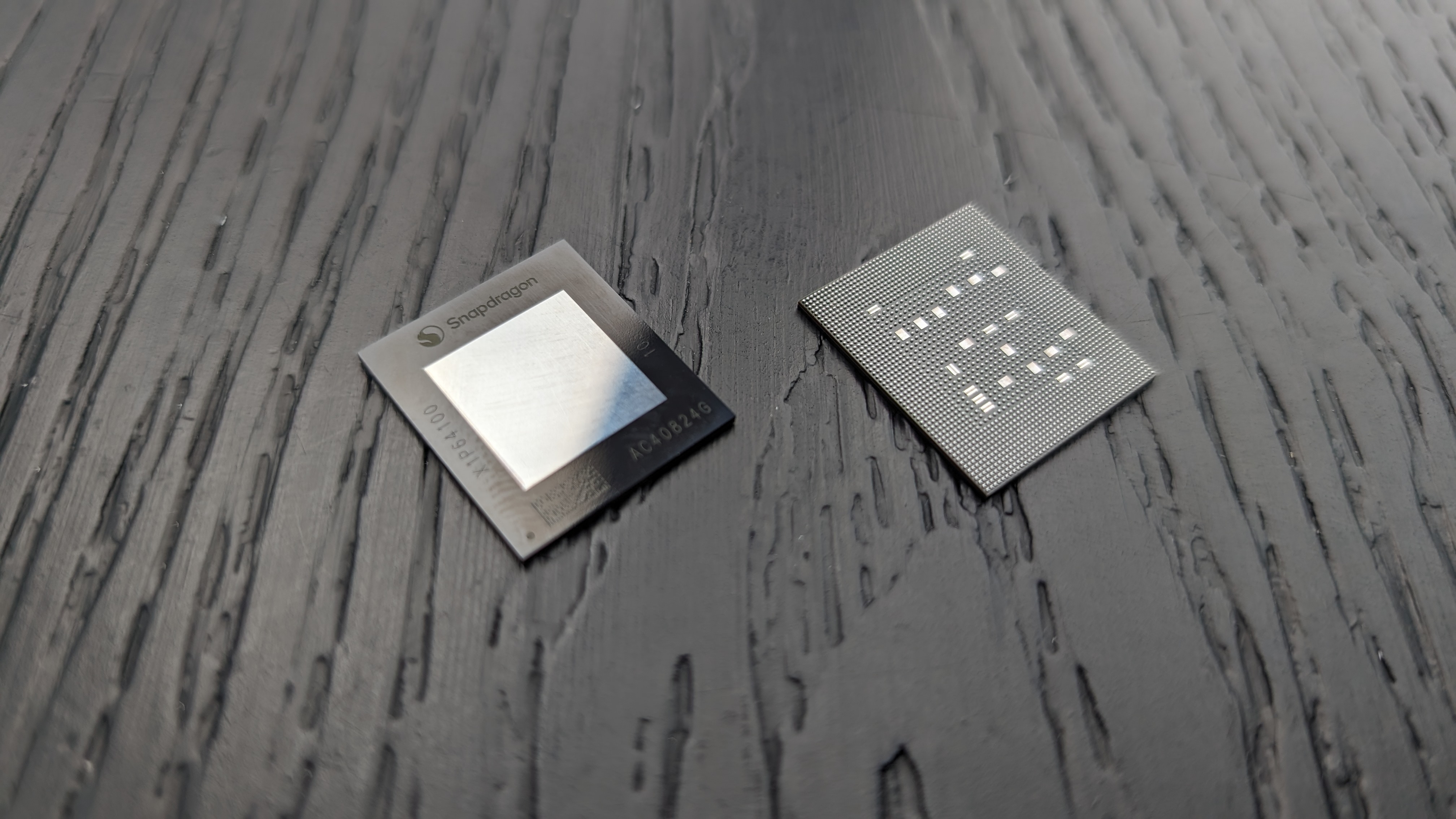 Siyah ahşap yüzey üzerinde bir Snapdragon X mikroçipi.