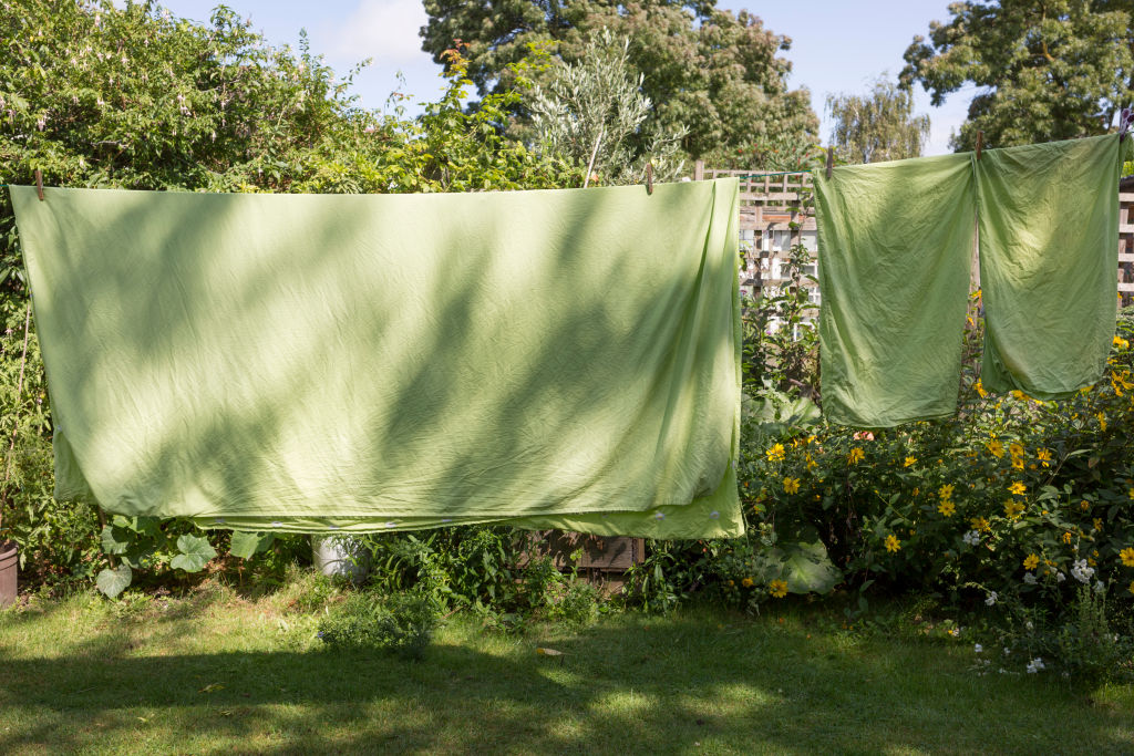 Çamaşır ipinde kuruyan bir dizi yeşil keten yatak çarşafı