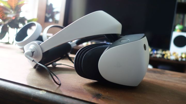 Ahşap bir masanın üzerinde duran PlayStation VR2'nin yandan görünümü.