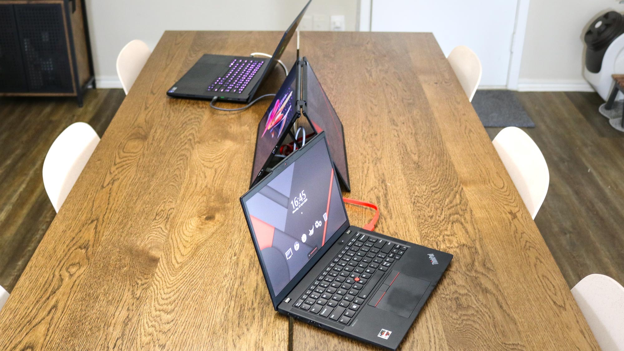 Mutfak masasında çadır modunda UPERFECT UStation Delta'ya bağlı iki dizüstü bilgisayar
