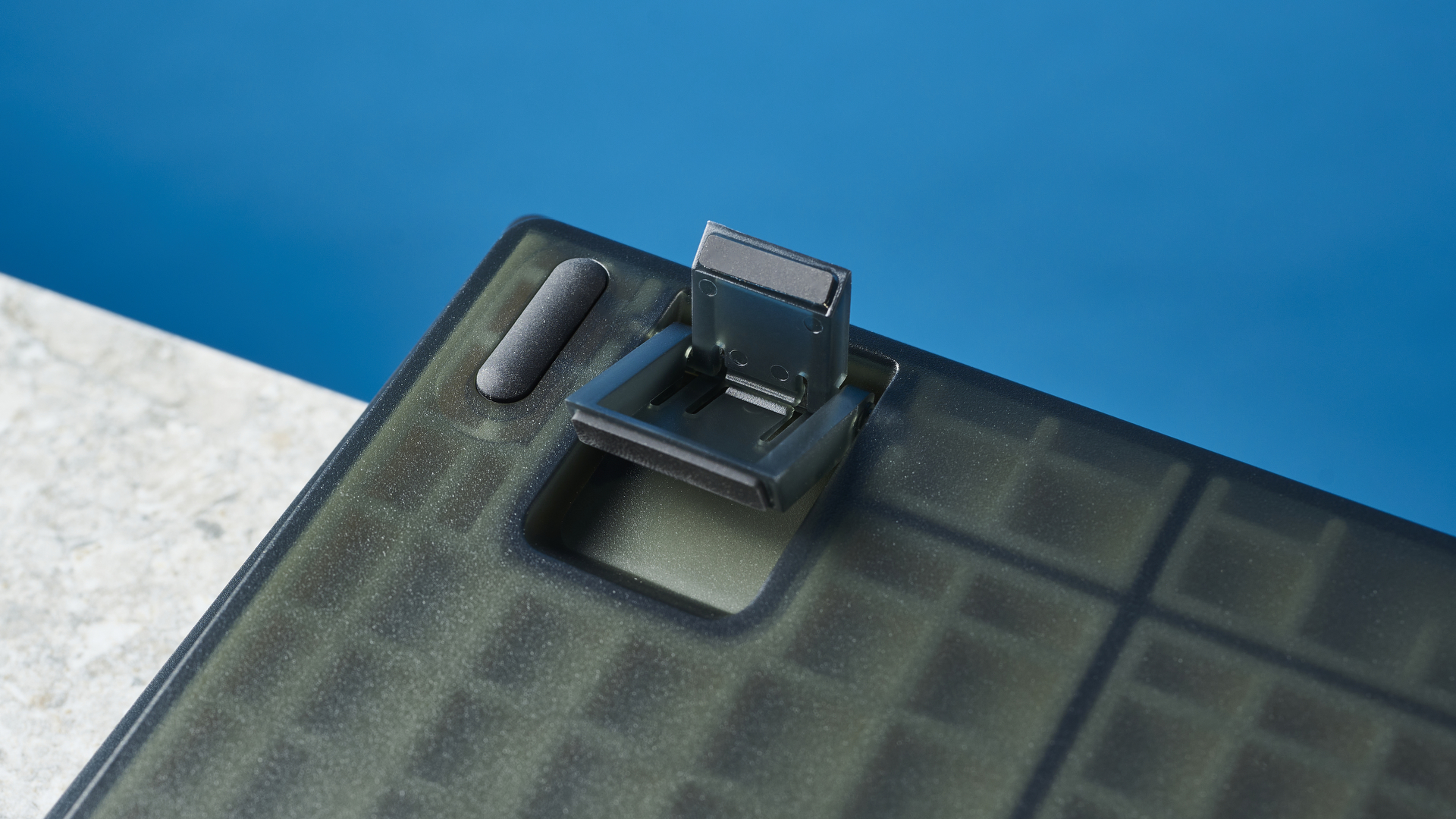Keychron V6'nın gri, siyah ve turuncu tuş kapaklı siyah fotoğrafı.  Klavye, arka planda mavi bir duvar bulunan taş bir arduvazın üzerine yerleştirilmiştir.