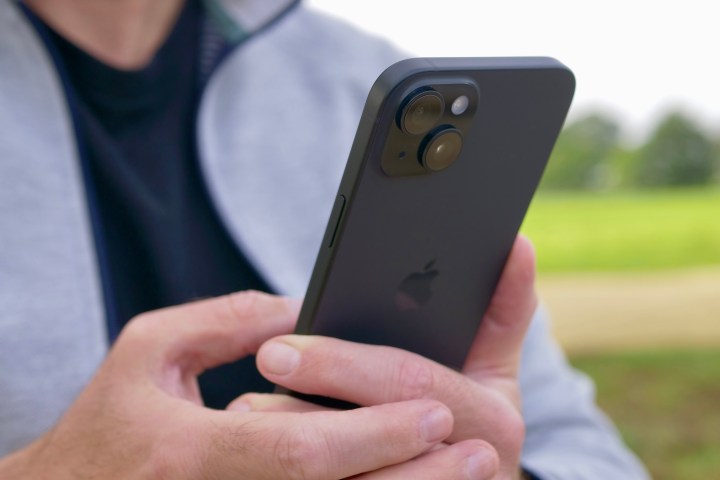 Apple iPhone 15 Plus'ı tutan bir kişi kamerayı gösteriyor.