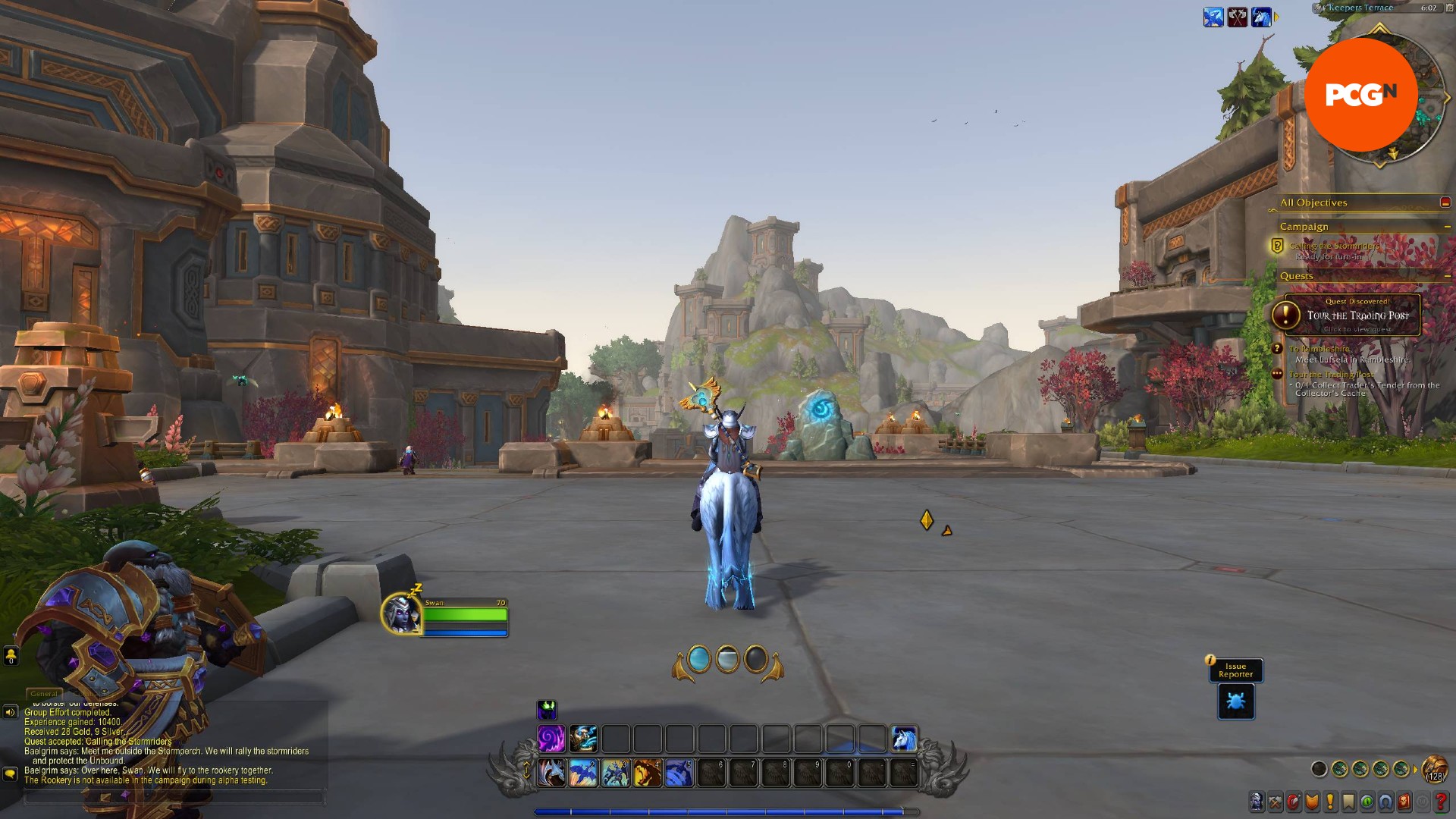 Bir World of Warcraft karakteri, kayalık bir şehir bölgesinde mavi kuyruklu bir tek boynuzlu atın üzerinde oturuyor