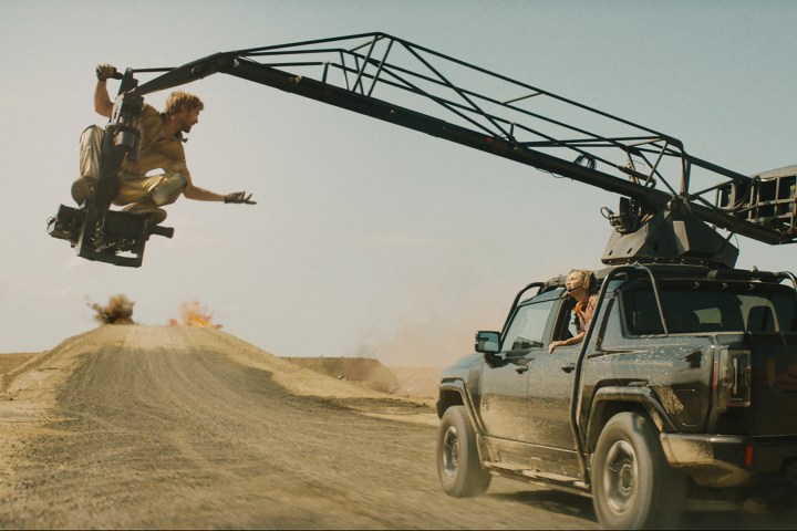 Ryan Gosling, The Fall Guy'da bir kamyonun yanındaki kamera kolunun üzerinde oturuyor.