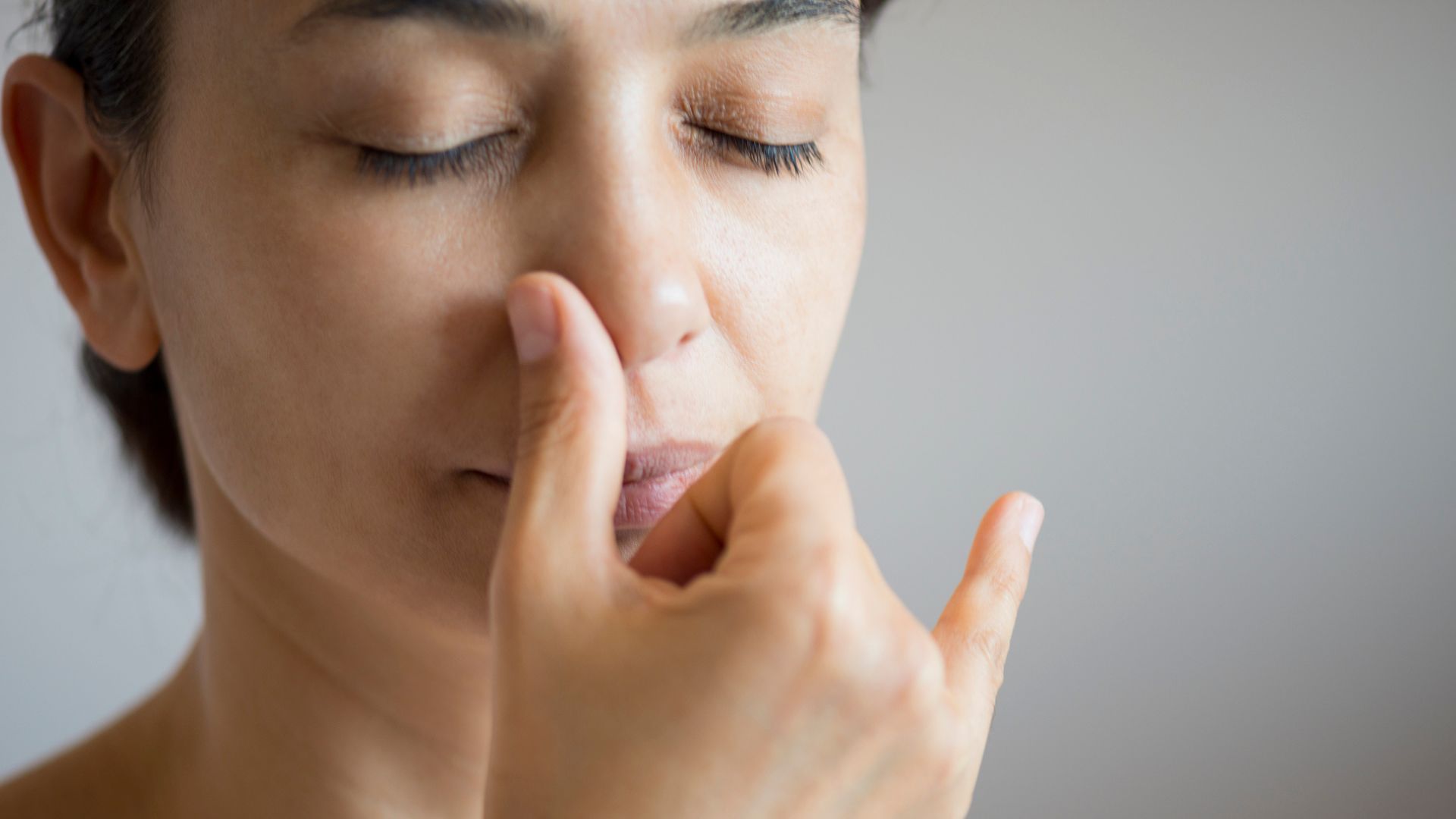 Alternatif burun deliği nefesi egzersizi yapan bir kadının yüzünün yakın plan görüntüsü