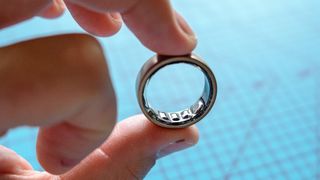 Bir kişinin parmakları arasında tutulan Amazfit Helio Yüzüğü