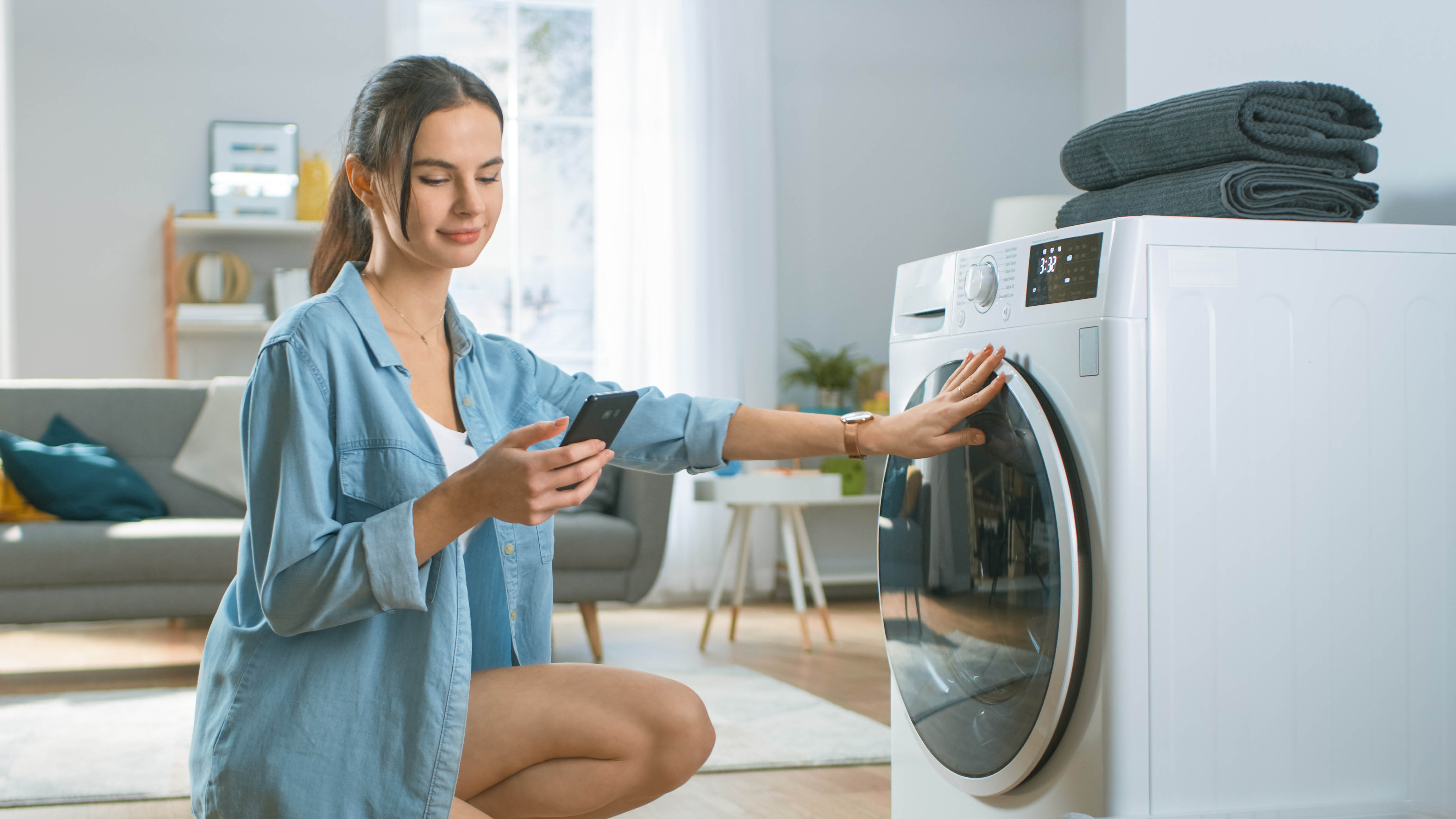 Uygulamayı akıllı çamaşır makinesine bağlayan kadın