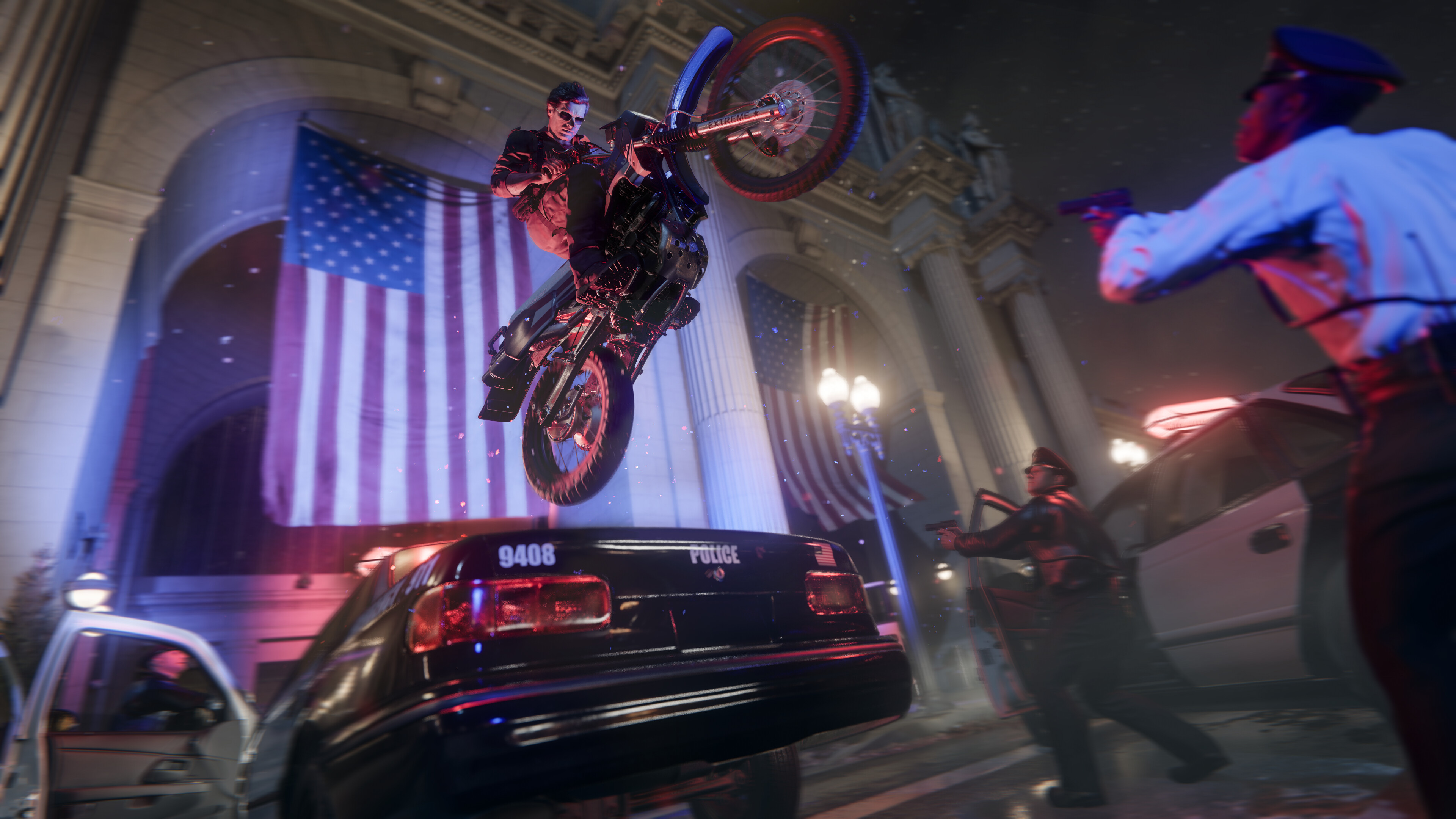 Call of Duty Black Ops 6'nın tanıtım ekran görüntüsünde, Adler'in arazi motosikletiyle arka planda Amerikan bayrakları bulunan bir polis arabasının üzerinden atladığı görülüyor.