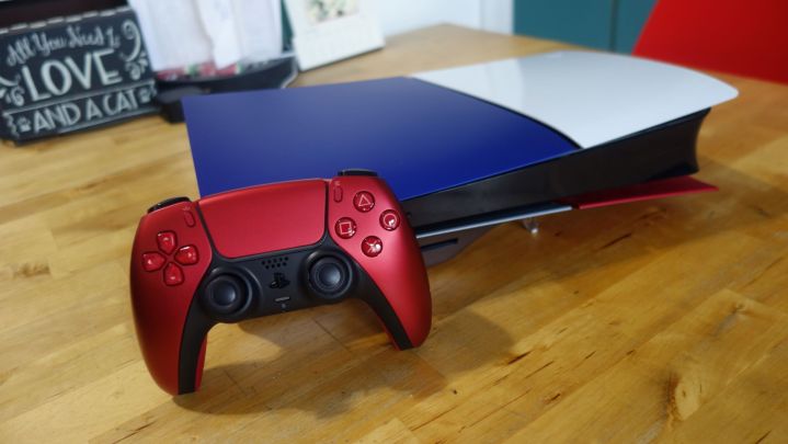 Bir PS5 slim, farklı renkli yüz plakalarına sahip bir masanın üzerinde duruyor.