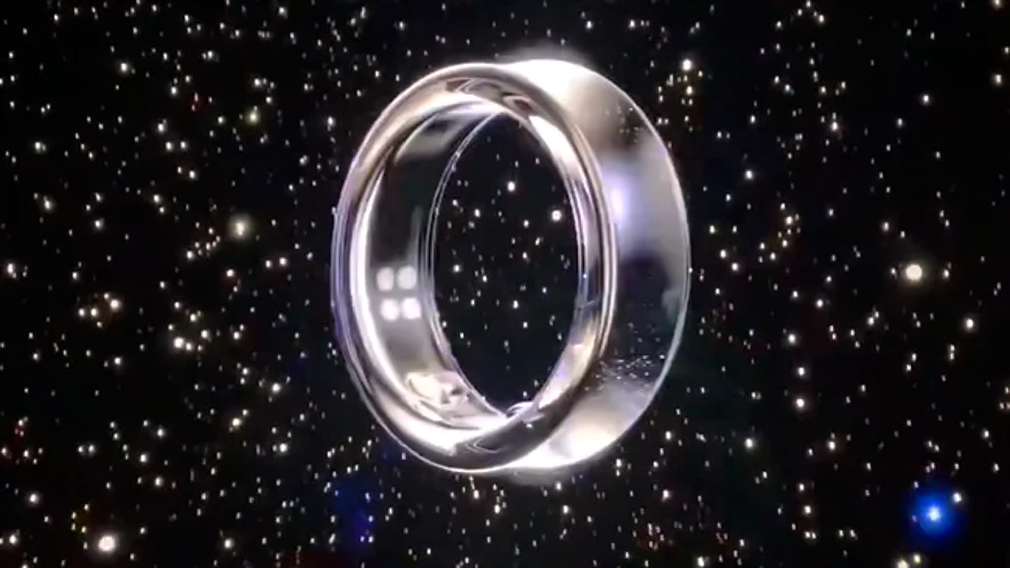 Yıldızlarla dolu uzay arka planına karşı gümüş renkli Samsung Galaxy Ring