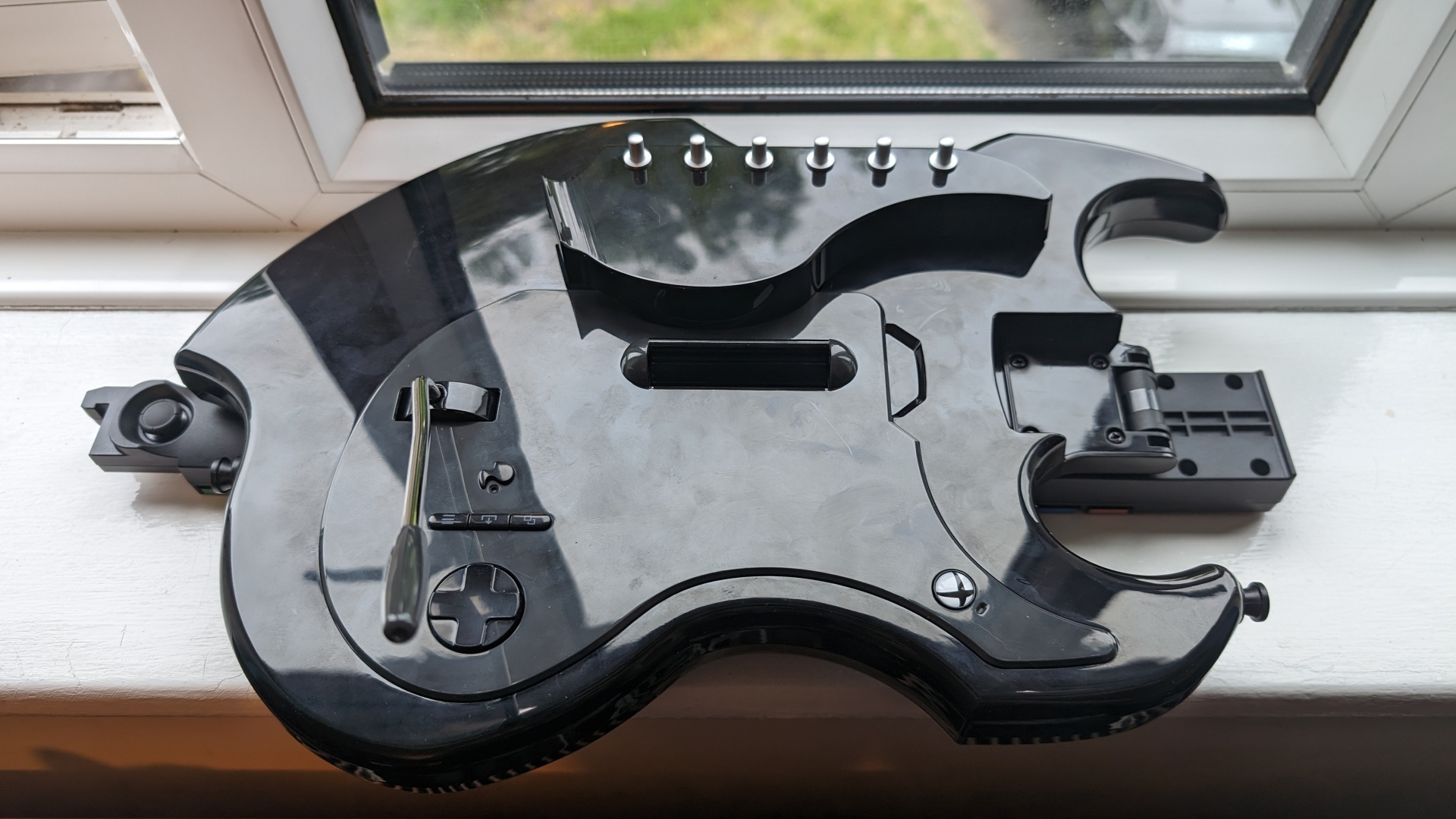 PDP Riffmaster Gitar Kontrolcüsü inceleme görüntüsünde, kontrolcünün pencere kenarında katlanmış hali gösteriliyor.