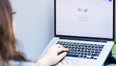 MacBook'ta Google aramayı kullanan kadın