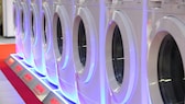 Bir ticaret fuarında çok sayıda çamaşır makinesi sıralandı.