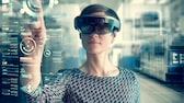 Yansıtılan ekranın arkasında Microsoft HoloLens kullanan kadın